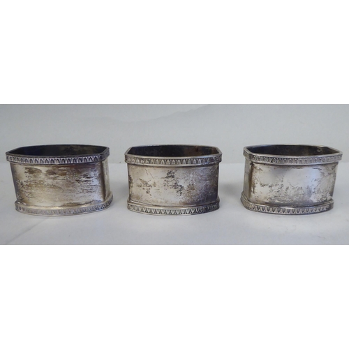 5 - A set of eight silver coloured metal oval napkin rings with egg and dart cast borders  bearing ... 