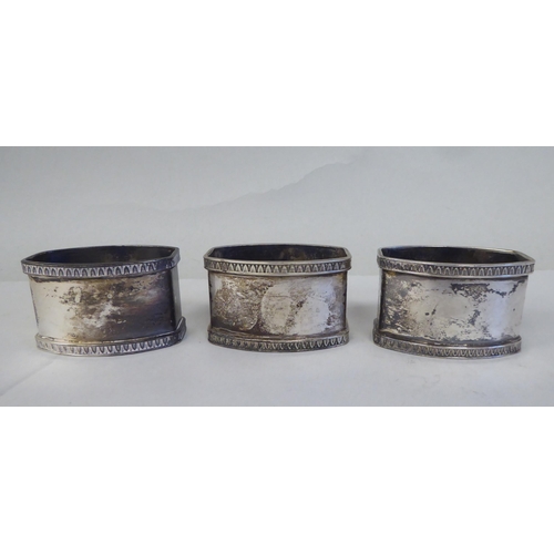 5 - A set of eight silver coloured metal oval napkin rings with egg and dart cast borders  bearing ... 