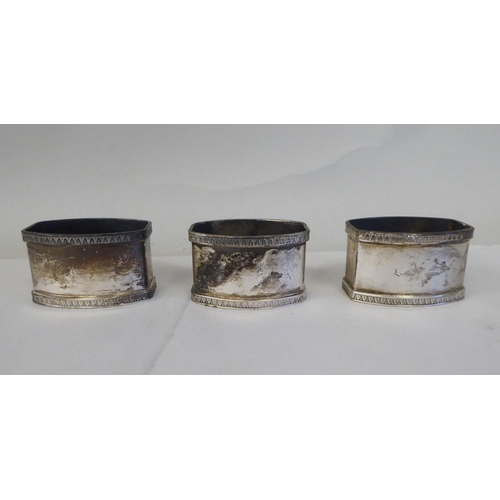 5 - A set of eight silver coloured metal oval napkin rings with egg and dart cast borders  bearing ... 