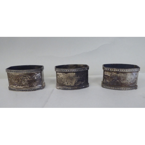 5 - A set of eight silver coloured metal oval napkin rings with egg and dart cast borders  bearing ... 