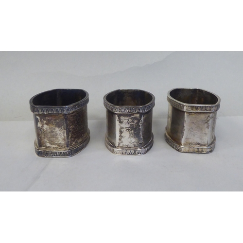 5 - A set of eight silver coloured metal oval napkin rings with egg and dart cast borders  bearing ... 