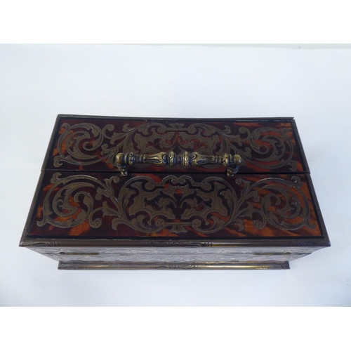 51 - A late 19thC desktop boulleworked tortoiseshell stand with straight sides and two outward hinged fla... 