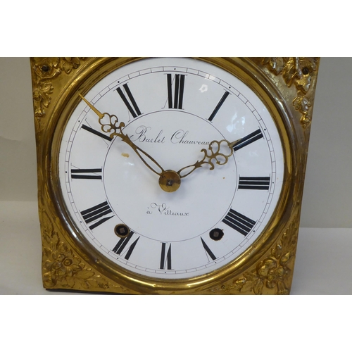 54 - A 19thC French Comptoise clock, faced by an elaborately pressed backplate, incorporating cherubic fi... 