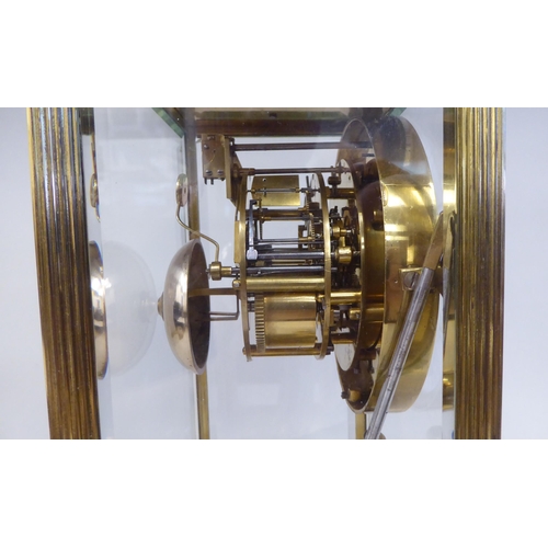 57 - A late Victorian lacquered brass, four glass mantel clock with bevelled panels; the visible bell str... 