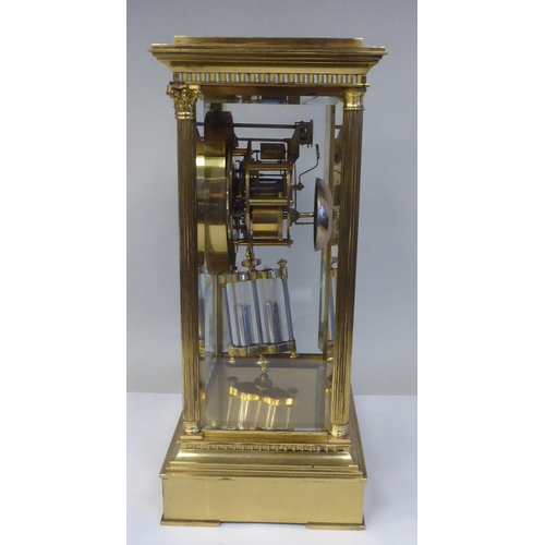 57 - A late Victorian lacquered brass, four glass mantel clock with bevelled panels; the visible bell str... 