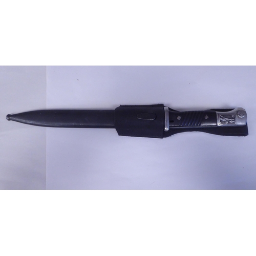 64 - A German World War II military bayonet with a two-part handgrip, the engraved blade 9.5