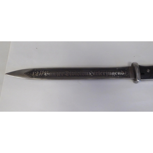 64 - A German World War II military bayonet with a two-part handgrip, the engraved blade 9.5