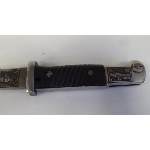 64 - A German World War II military bayonet with a two-part handgrip, the engraved blade 9.5