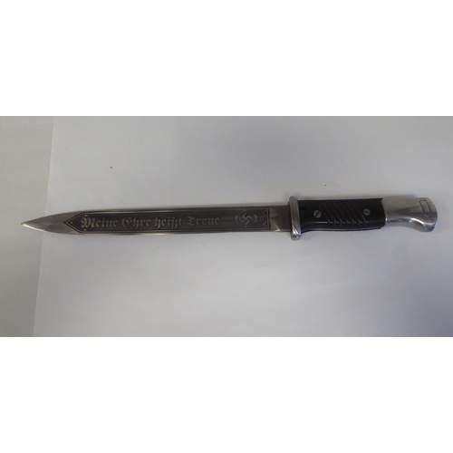 64 - A German World War II military bayonet with a two-part handgrip, the engraved blade 9.5