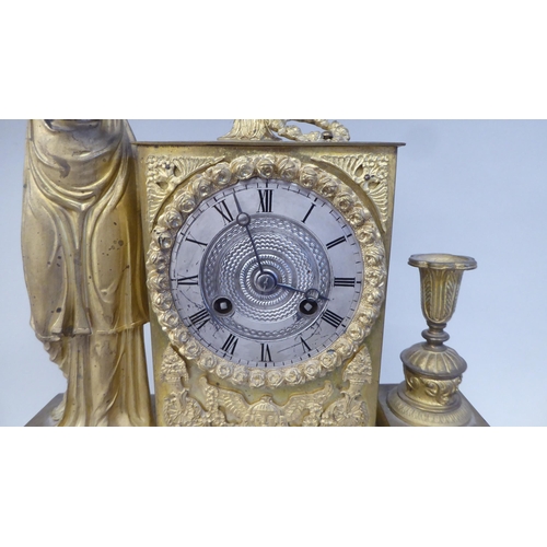 65 - A late 19thC Continental gilded metal cased mantel clock, ornamented with a standing classical maide... 