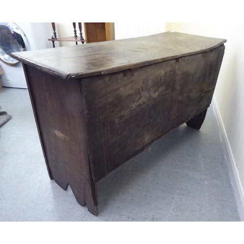 77 - A 17thC boarded oak coffer with a tri-panelled front, incorporating lunette and foliate carved ornam... 