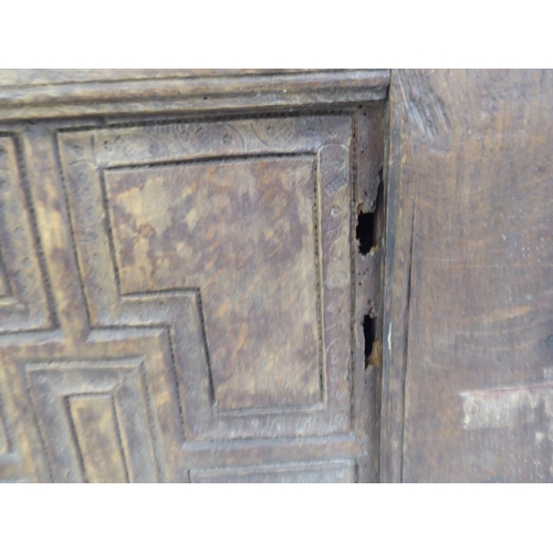 77 - A 17thC boarded oak coffer with a tri-panelled front, incorporating lunette and foliate carved ornam... 