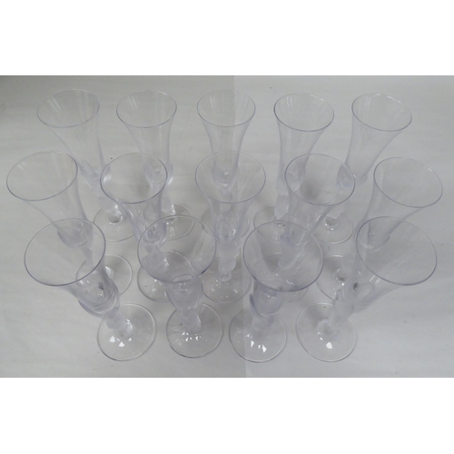 83 - A set of fourteen part frosted glass pedestal Champagne flutes, the trumpet shaped bowls elevated on... 