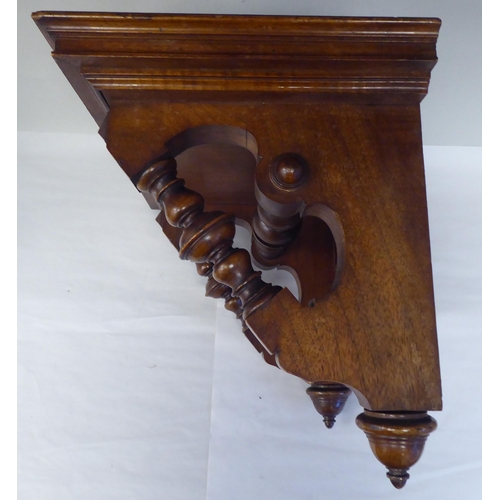 95 - A late Victorian walnut clock bracket, the platform top over a series of elaborately turned supports... 