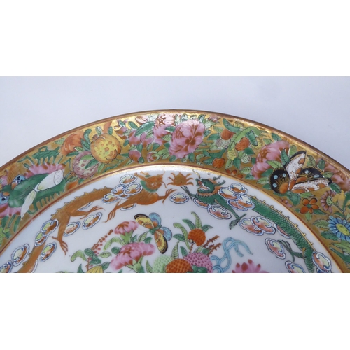 96 - A 19thC Chinese porcelain dish, decorated in famille rose and gilding with fruit, insects and dragon... 