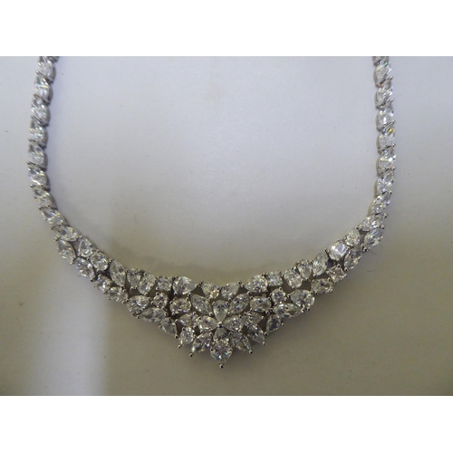 227 - A silver necklace, set with multiple white stones