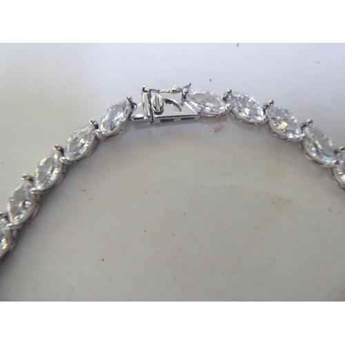 227 - A silver necklace, set with multiple white stones