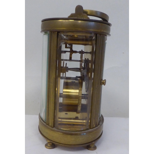 23 - An early 20thC French oval brass cased carriage timepiece with bevelled glass panels and a folding t... 