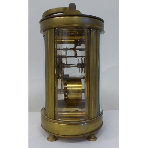 23 - An early 20thC French oval brass cased carriage timepiece with bevelled glass panels and a folding t... 