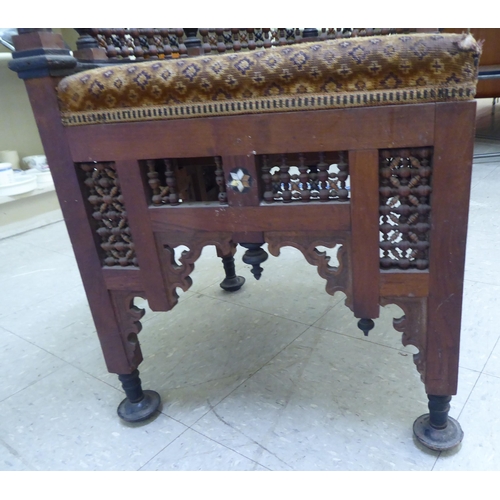 240 - A late 19thC Moorish mother-of-pearl inlaid fruitwood corner chair with an upholstered seat, raised ... 