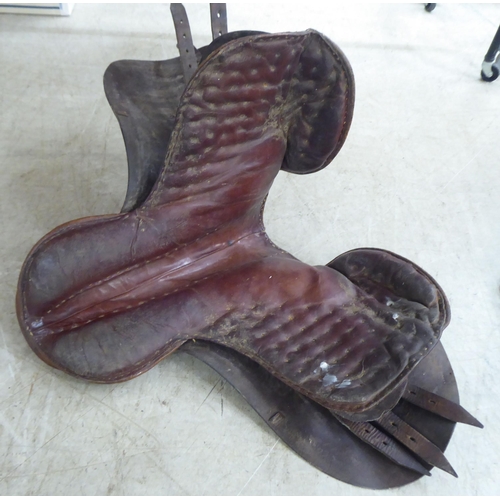 134 - Two brown hide horse saddles; and another in black hide