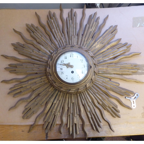 140 - An early 20thC carved giltwood cased sunburst wall clock; the movement faced by a convex white ename... 