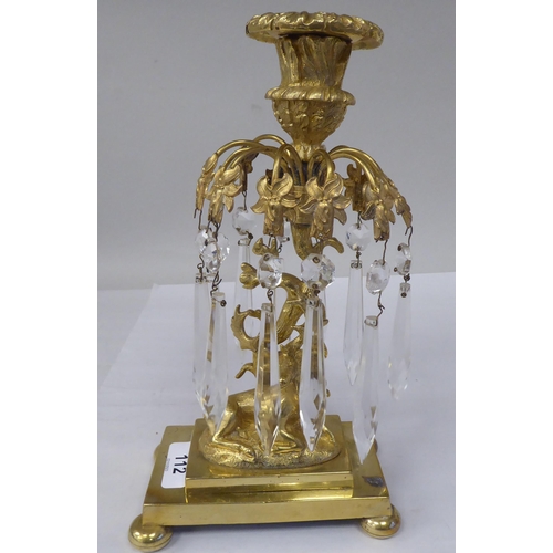 144 - A 19thC gilt metal candlestick with a detachable sconce, in a vase shape socket, over a series of tw... 