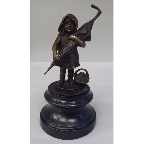 145 - A cast and patinated bronze figure, a little girl carrying an adult's umbrella, on a turned wooden p... 