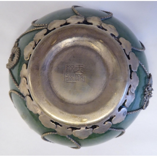 218 - A 20thC Chinese green jadeite bowl, set in a white metal frame  4.25