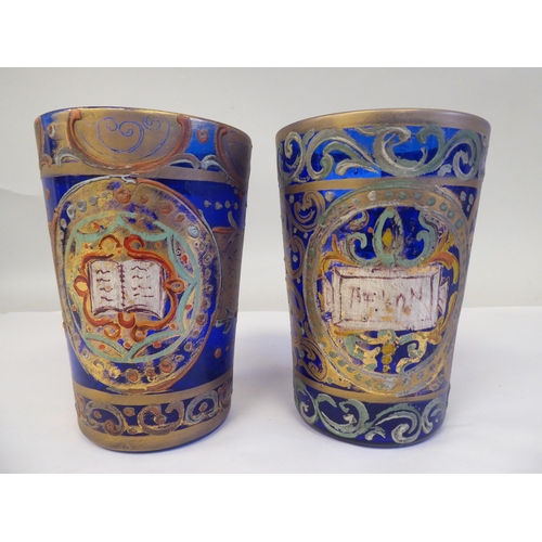 232 - A pair of 19thC Continental blue glass beakers of tapered form, similarly overpainted and gilded wit... 