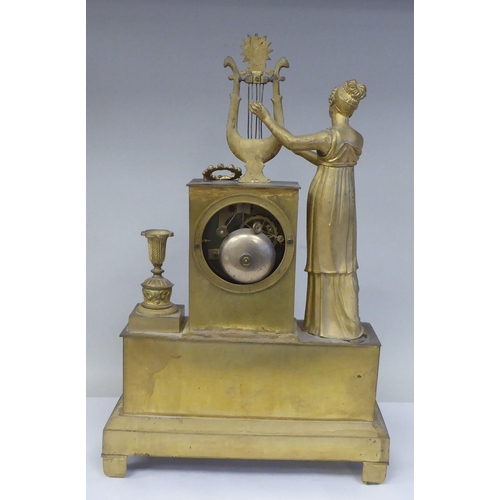 293 - A late 19thC Continental gilded metal cased mantel clock, ornamented with a standing classical maide... 