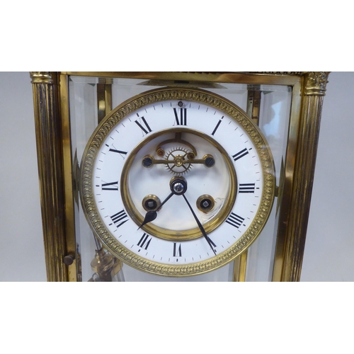 298 - A late Victorian lacquered brass, four glass mantel clock with bevelled panels; the visible bell str... 