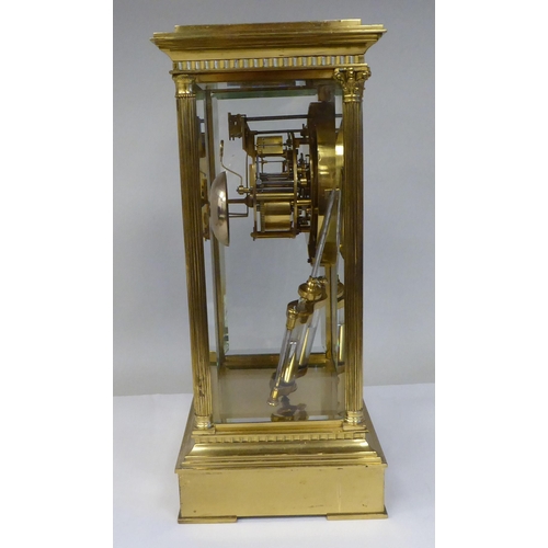 298 - A late Victorian lacquered brass, four glass mantel clock with bevelled panels; the visible bell str... 