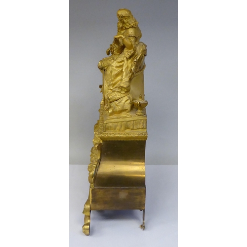 308 - A 19thC French gilt metal cased mantel clock, featuring a seated couple, on a draped cushion, the de... 