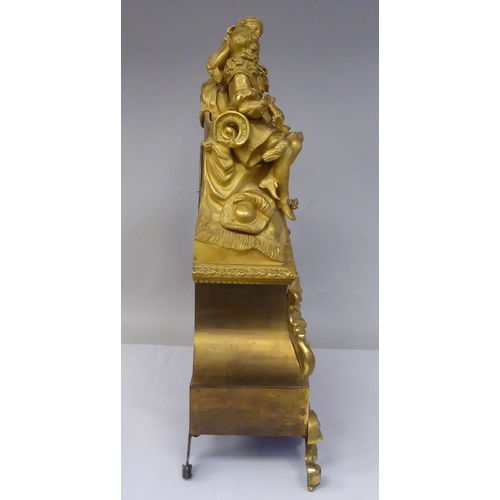 308 - A 19thC French gilt metal cased mantel clock, featuring a seated couple, on a draped cushion, the de... 