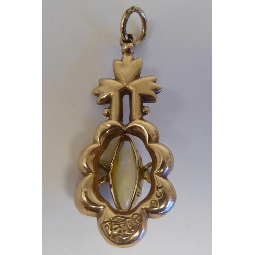 109 - A yellow metal pendant, set with a central opal, featuring a floral motif  stamped 9ct 