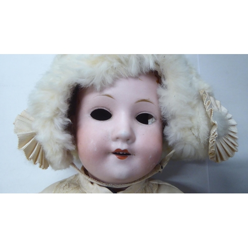 15 - An early 20thC Max Oscar Arnold Welsch bisque head doll with painted features, on a jointed composit... 