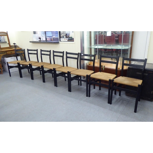 162 - A set of eight modern black painted, twin bar back chairs with rush seats