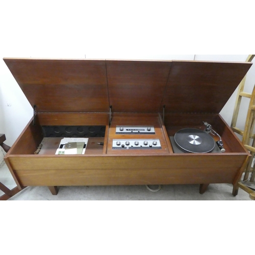 163 - A 1960/1970s Leak teak cased low cabinet with three hinged flaps, containing a stereo 30 and a Garra... 