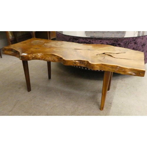 165 - A rustically constructed waxed elm coffee table of natural form, raised on tapered legs  16