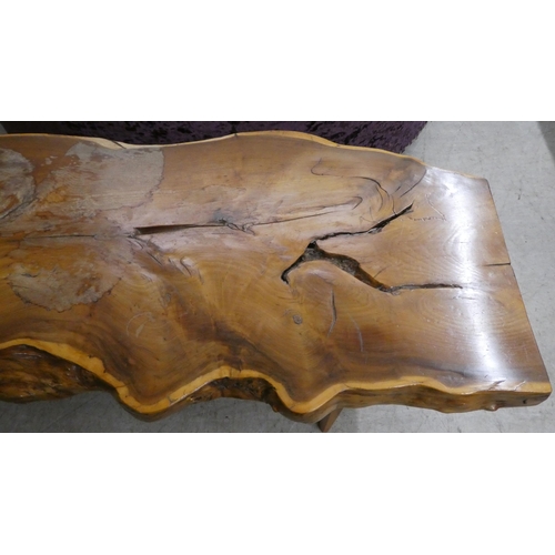 165 - A rustically constructed waxed elm coffee table of natural form, raised on tapered legs  16