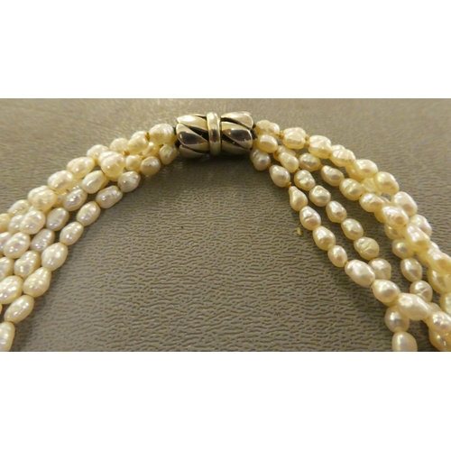 180 - A freshwater pearl necklace, consisting of five strands, connected by a white metal clasp  stam... 