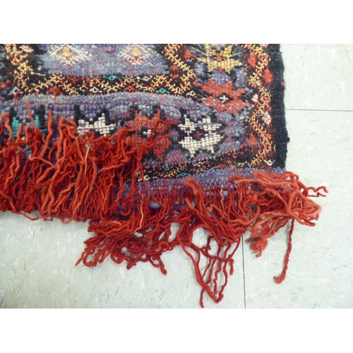 262 - Rugs: to include a Bokhara with elephant foot motifs, on a red ground  50