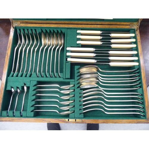 277 - A mid 20thC EPNS and stainless steel canteen, in a contemporary fitted oak case 