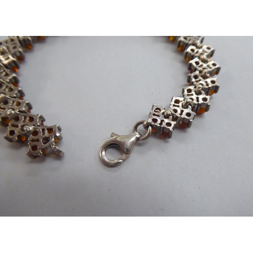 302 - A silver bracelet, set with amber coloured beads; and a matching necklace