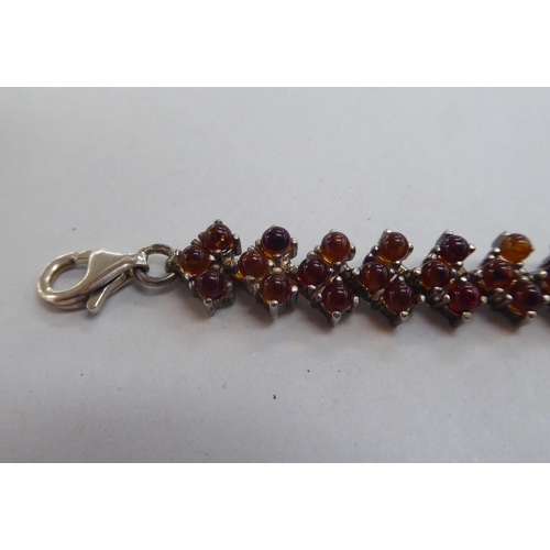 302 - A silver bracelet, set with amber coloured beads; and a matching necklace