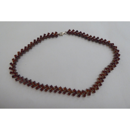 302 - A silver bracelet, set with amber coloured beads; and a matching necklace