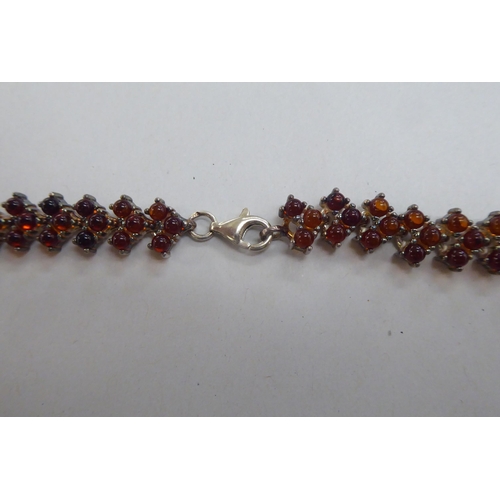 302 - A silver bracelet, set with amber coloured beads; and a matching necklace