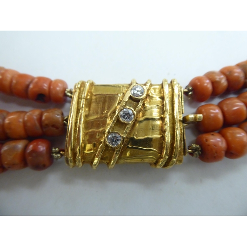 306 - A triple row coral string necklace with an 18ct gold and three diamond set clasp