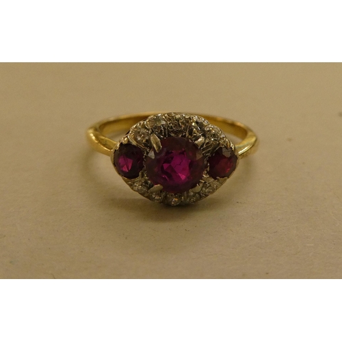 320 - A yellow metal ring, set with diamonds and red stones